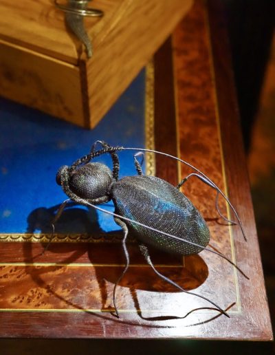 Giant Peacock Beetle £550. Body wrapped in navy blue silk with peacock feathers under veiling to represent iridescence, legs and antennae bound with silk thread and velvet to suggest segments. Size H 5 x L 12 x W 10cm. Sales: contact Bridget at studio@bridgetbailey.co.uk